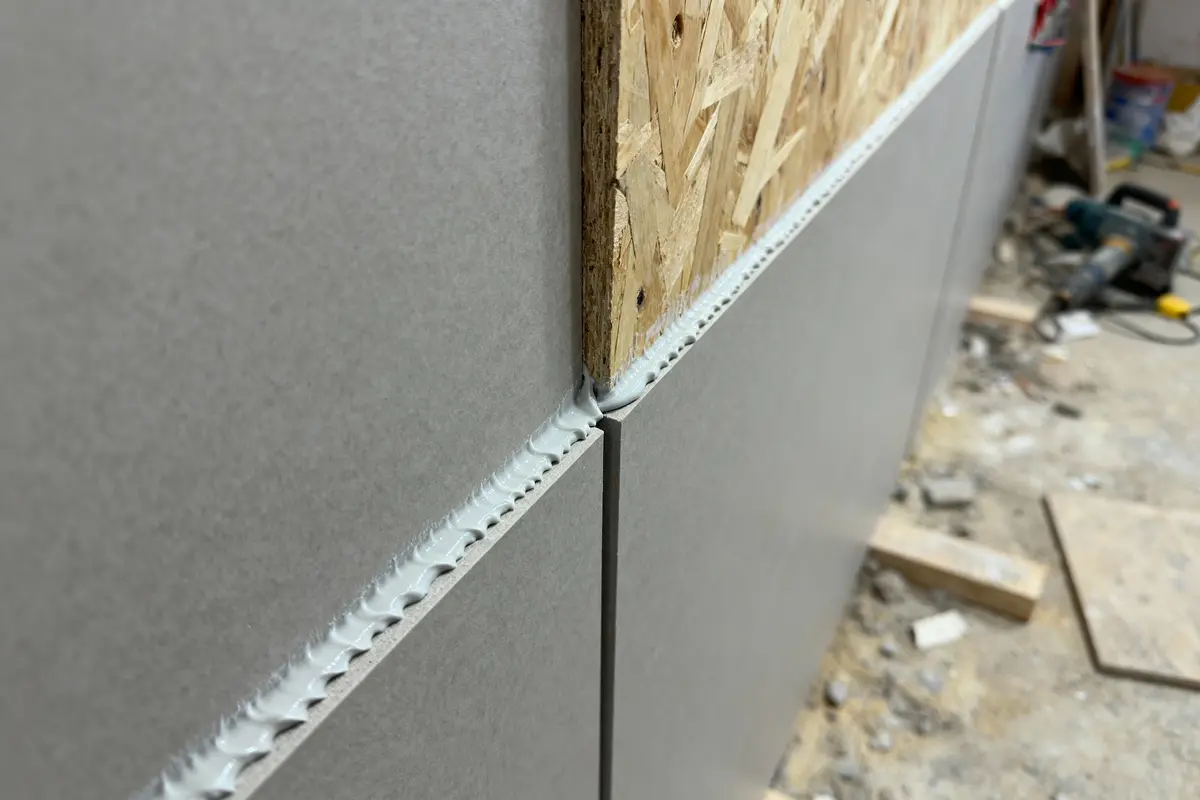 Panneau OSB et plaques de plâtre assemblés avec joint en construction intérieure en cours.