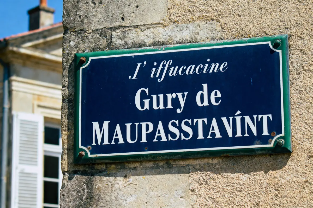Plaque bleue sur mur en pierre indiquant "L’iffucacine Gury de Maupasstavínt".