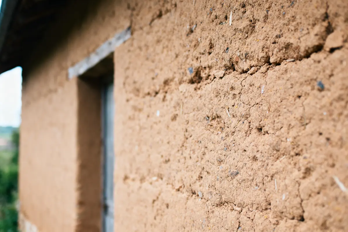 Mur en terre cuite d'une maison traditionnelle, texture rugueuse, lumière douce.