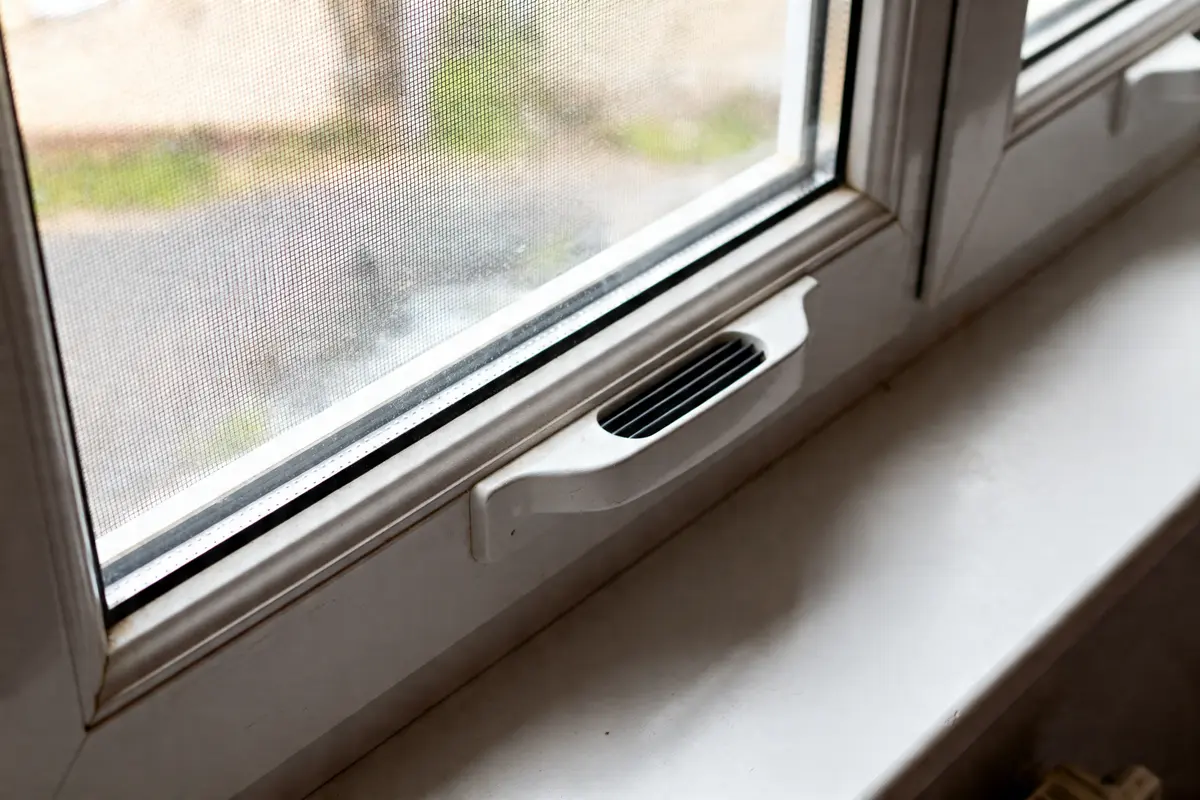 Vue détaillée d'un système d'aération fenêtre PVC pour améliorer ventilation intérieure