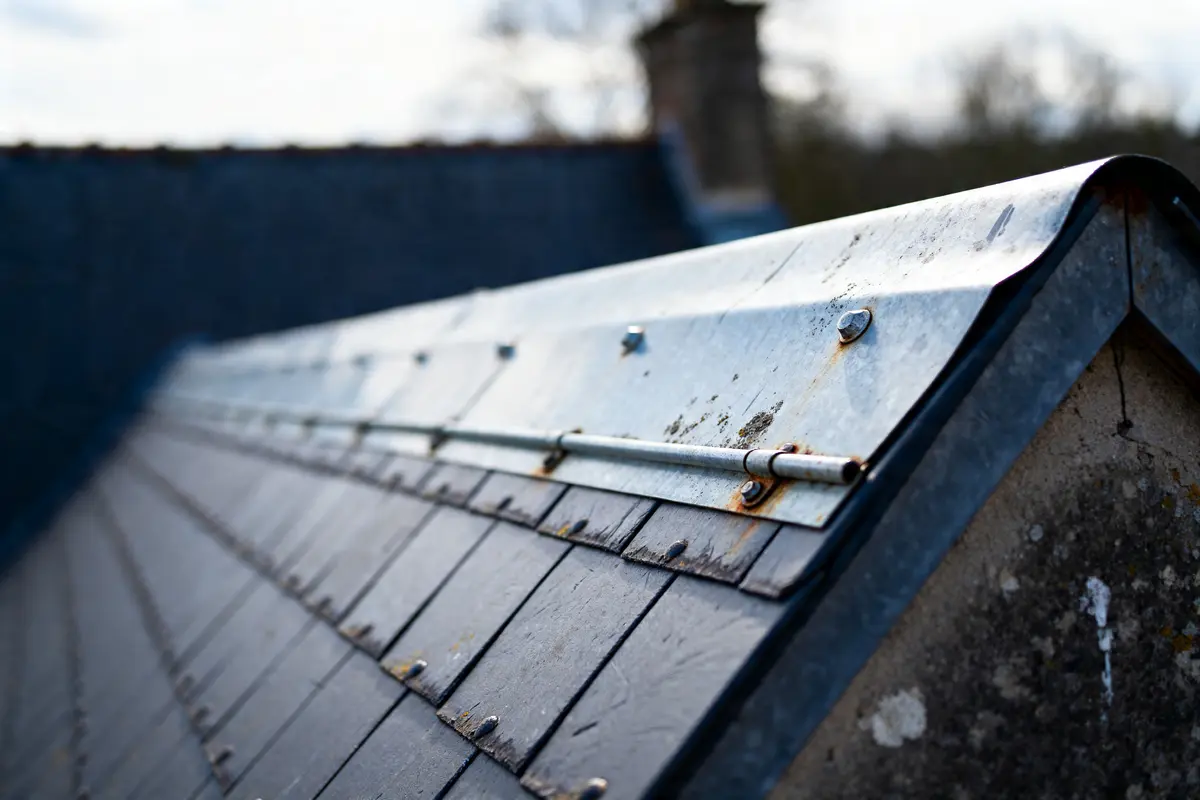 Toiture en ardoise avec chéneau toiture métallique fixée par vis et boulons