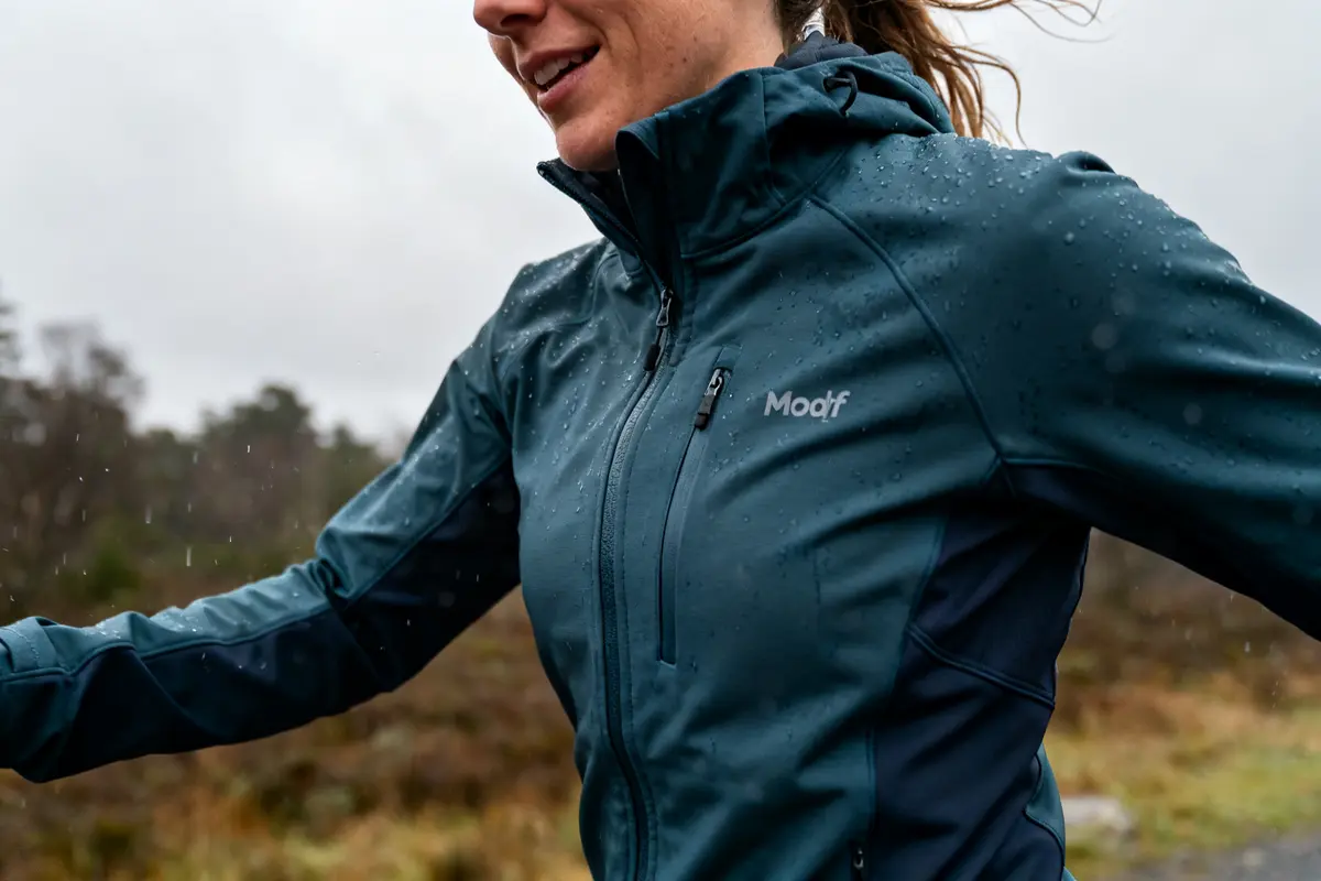 Personne courant sous la pluie portant une veste softshell Modyf idéale pour l'extérieur